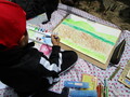 子どもが風景画を描いている様子の画像